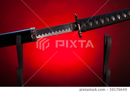Katana on stand with red lighting, partially drawn blade. Katana on stand with red lighting, partially drawn blade. 39176649