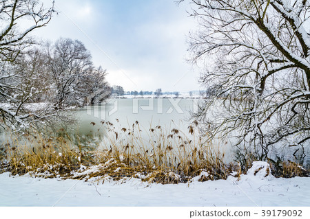 Part frozen pond and path around it in the winter Part frozen pond and path around it in the winter 39179092