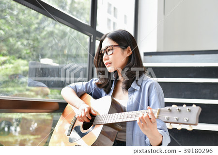 Music Concepts. Asian girls playing guitar. Asian women relaxing Music Concepts. Asian girls playing guitar. Asian women relaxing 39180296