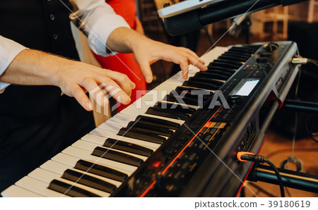 musical synthesizer to which the hands of a man musical synthesizer to which the hands of a man 39180619