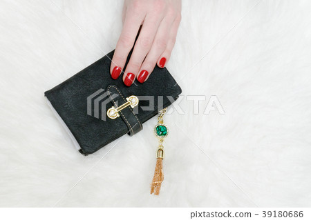 Black wallet in female hand. White fur 39180686