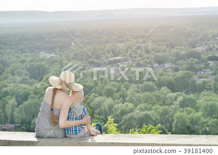 Mom and son sitting on background of green forest 39181400