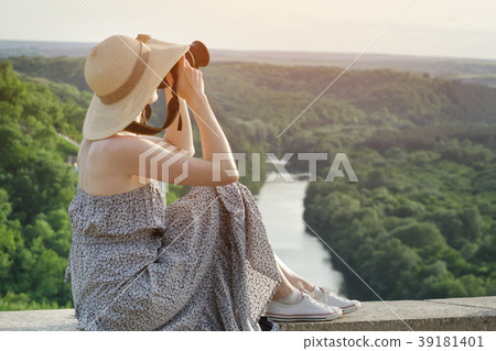 Side view of a girl with a camera. View from hill 39181401