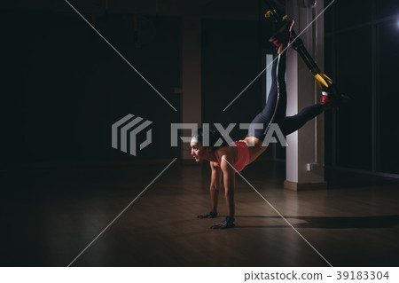 Strong woman doing trx exercise with straps Strong woman doing trx exercise with straps 39183304
