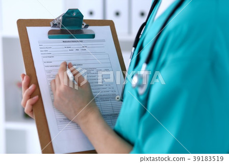 Female doctor filling up medical form on clipboard 39183519