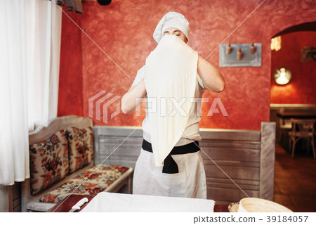 Chef in apron and hat making dough on the kitchen Chef in apron and hat making dough on the kitchen 39184057