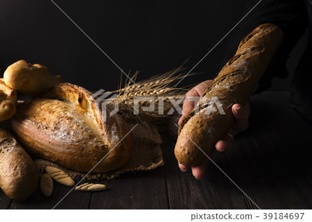 Baker woman holding rustic organic loaf of bread 39184697