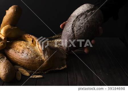 Baker woman holding rustic organic loaf of bread 39184698