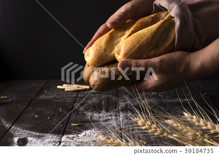 Baker woman holding rustic organic loaf of bread Baker woman holding rustic organic loaf of bread 39184735