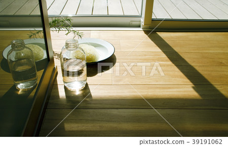 An oil bottle and sponge placed on the floor of the washroom next to the deck 39191062