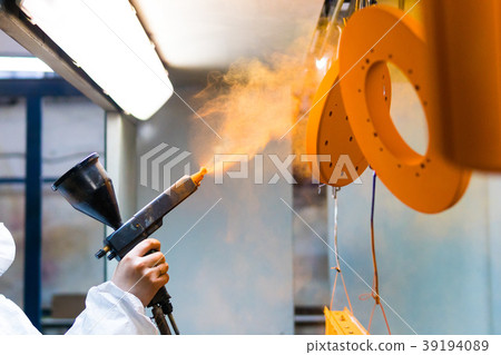 Powder coating of metal parts. A woman in a 39194089