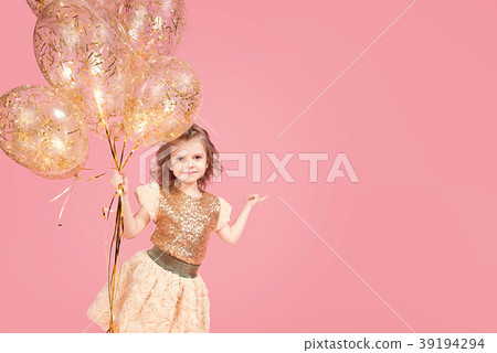 Happy young girl holding bunch of balloons Happy young girl holding bunch of balloons 39194294