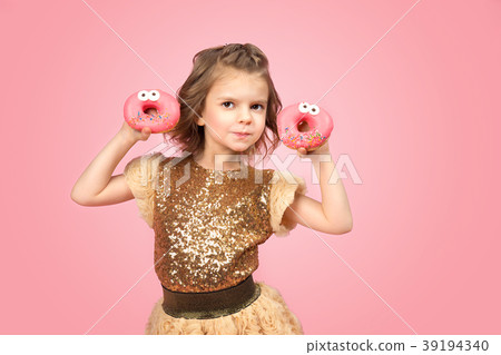 Little girl in dress with donuts 39194340