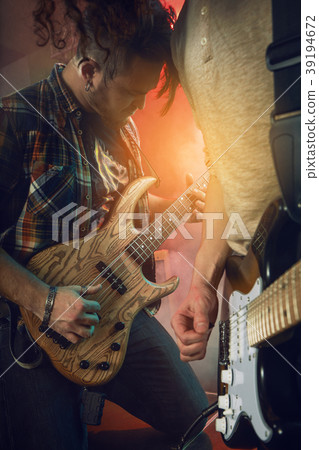 The musician plays an acoustic guitar. Scene The musician plays an acoustic guitar. Scene 39194672