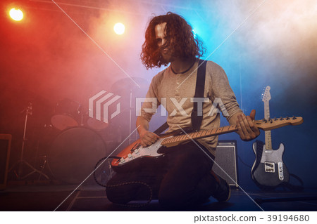 The musician plays an acoustic guitar. Scene 39194680