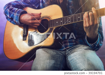 The musician plays an acoustic guitar. Scene 39194701