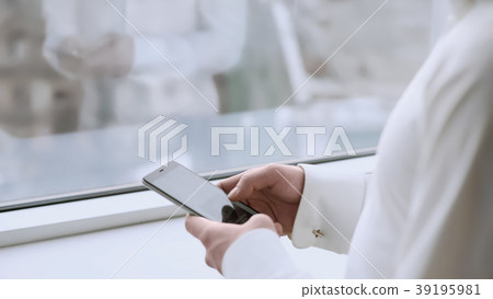 Male boss scrolling touchscreen on smartphone Male boss scrolling touchscreen on smartphone 39195981