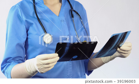 Trauma surgeon holding patient x-ray result making Trauma surgeon holding patient x-ray result making 39196003