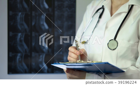Surgeon writing down patient diagnosis in medical Surgeon writing down patient diagnosis in medical 39196224