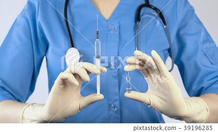 Physician holding vaccine and syringe in hands Physician holding vaccine and syringe in hands 39196285