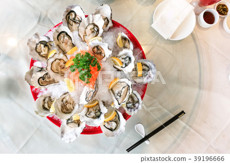 Fresh live raw oyster served with lemon and chili  39196666