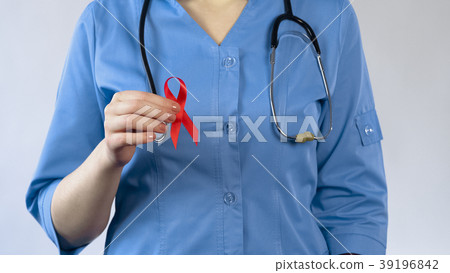 Female doctor showing red ribbon, AIDS awareness Female doctor showing red ribbon, AIDS awareness 39196842