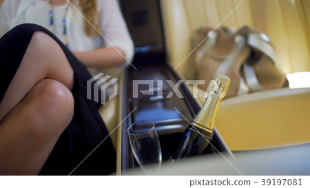 Glamorous woman sitting in expensive car, bottle 39197081