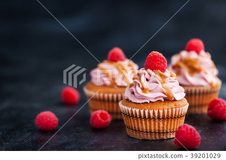 Raspberry and caramel cupcakes on dark background Raspberry and caramel cupcakes on dark background 39201029