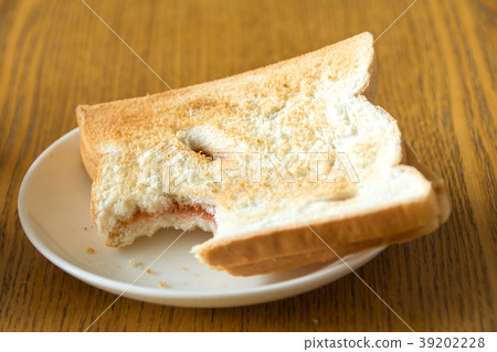 bitten bread in a white plate on wooden table bitten bread in a white plate on wooden table 39202228