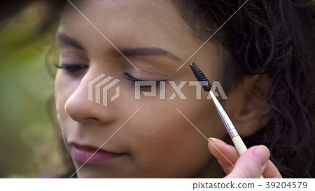 Makeup artist preparing beautiful young woman for Makeup artist preparing beautiful young woman for 39204579