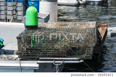Lobster trap and buoy on back of boat 39205421