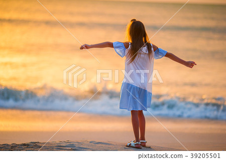 Adorable happy little girl walking on white beach Adorable happy little girl walking on white beach 39205501