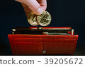 Human hand put in red long wallet two coins 39205672
