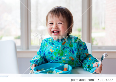 Toddler boy with a big smile eating food Toddler boy with a big smile eating food 39205822