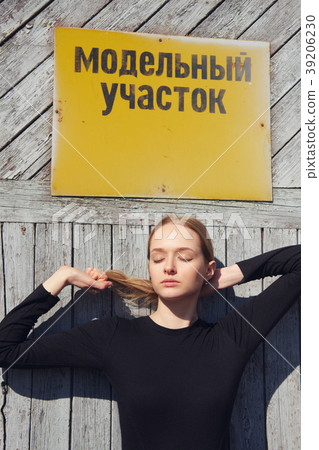 model posing near factory door with warning plate 39206230