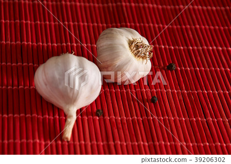 Garlic and black pepper on the red wooden table 39206302