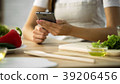 Close-up of female hands scrolling on smartphone 39206456