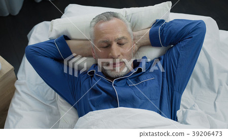 Top view of happy aged male lying in his bed and Top view of happy aged male lying in his bed and 39206473