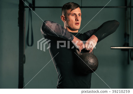 Concentrated young man working out at the gym Concentrated young man working out at the gym 39210259