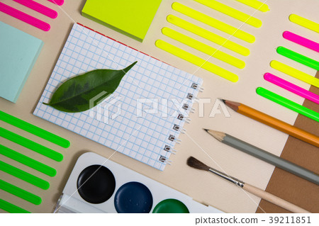 Green leaf on a notebook and school supplies Green leaf on a notebook and school supplies 39211851
