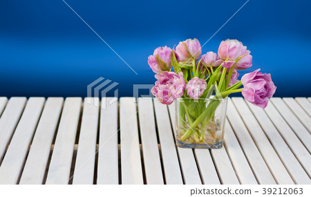 Purple tulips in the glass vase on the white Purple tulips in the glass vase on the white 39212063