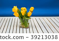 yellow tulips in the glass vase on the white 39213038