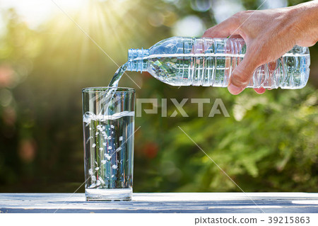Hand pouring drinking water from into glass Hand pouring drinking water from into glass 39215863