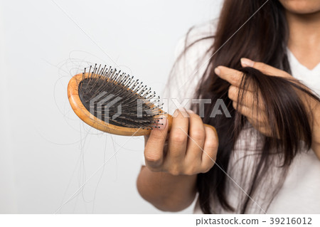 young woman worried about hair loss on a white bac 39216012