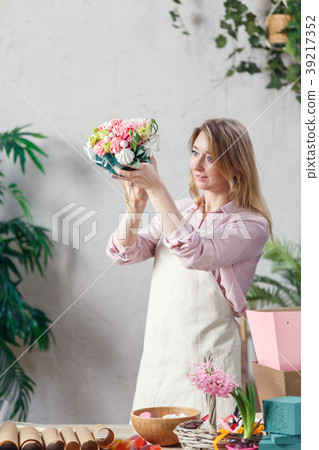 Portrait of florist holding bouquet in hands at 39217352