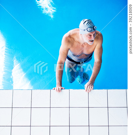 Senior man in an indoor swimming pool. Senior man in an indoor swimming pool. 39218009