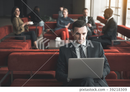 Serious young workaholic with laptop Serious young workaholic with laptop 39218309