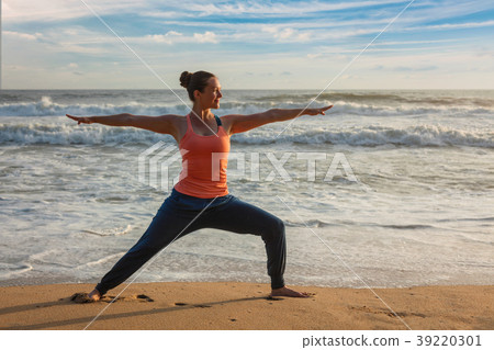 Woman doing yoga asana Virabhadrasana 1 Warrior 39220301