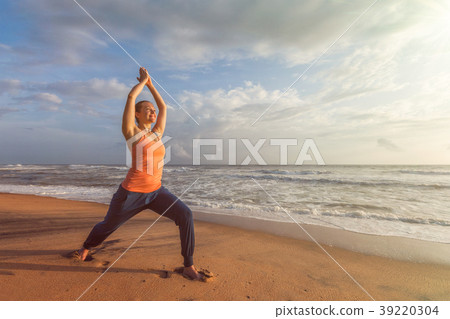 Woman doing yoga asana Virabhadrasana 1 Warrior 39220304