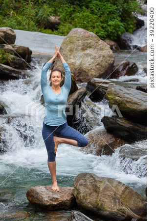 Woman in yoga asana Vrikshasana tree pose at Woman in yoga asana Vrikshasana tree pose at 39220400